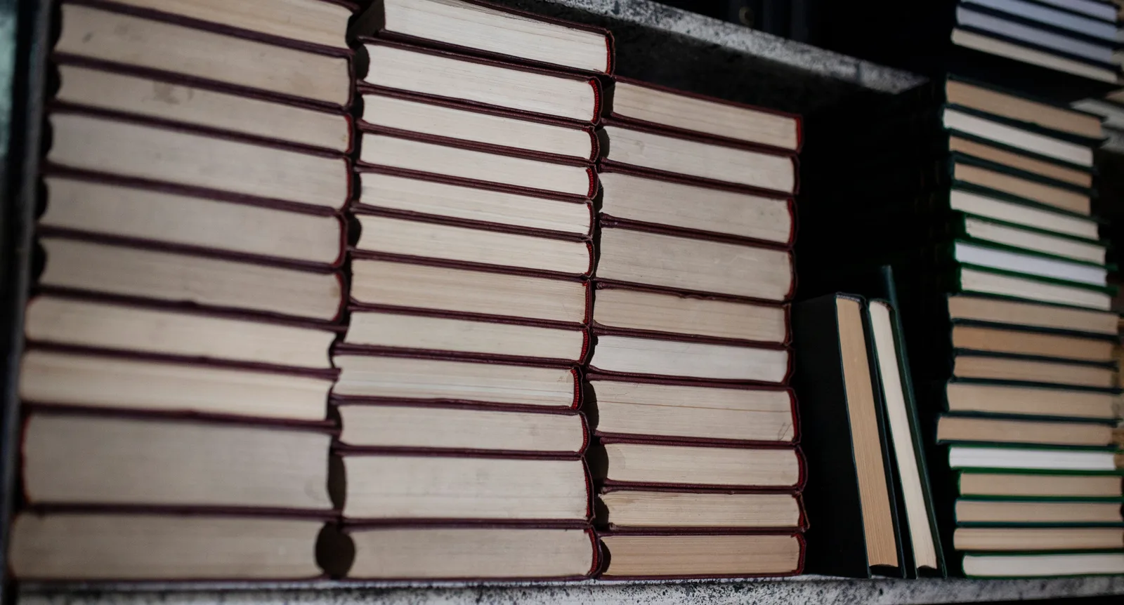 Bücherstapel in einem Regal, aufgenommen von der Seite