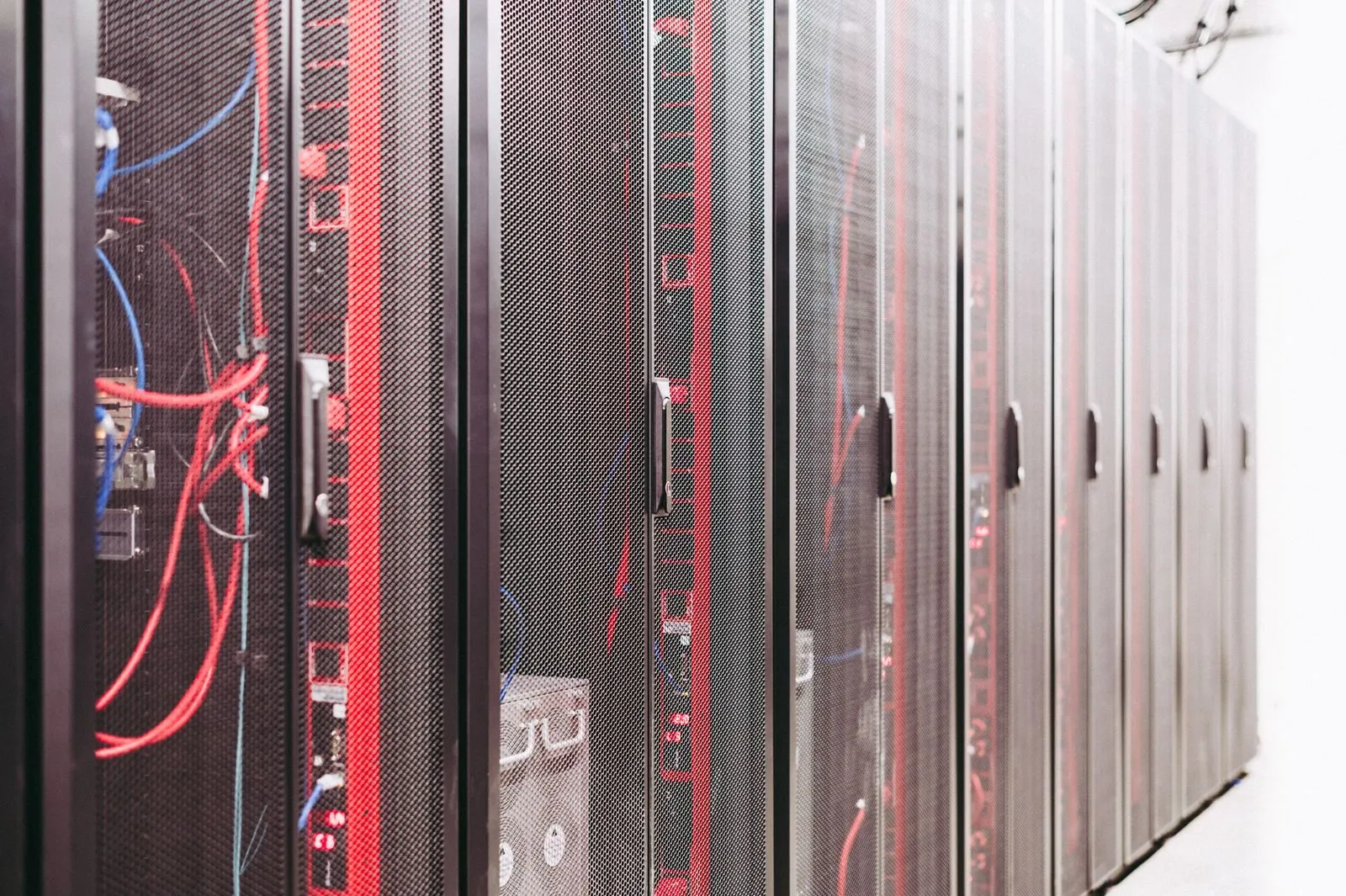 Netzwerkschrank mit vielen Kabeln, die an Server und Switches angeschlossen sind