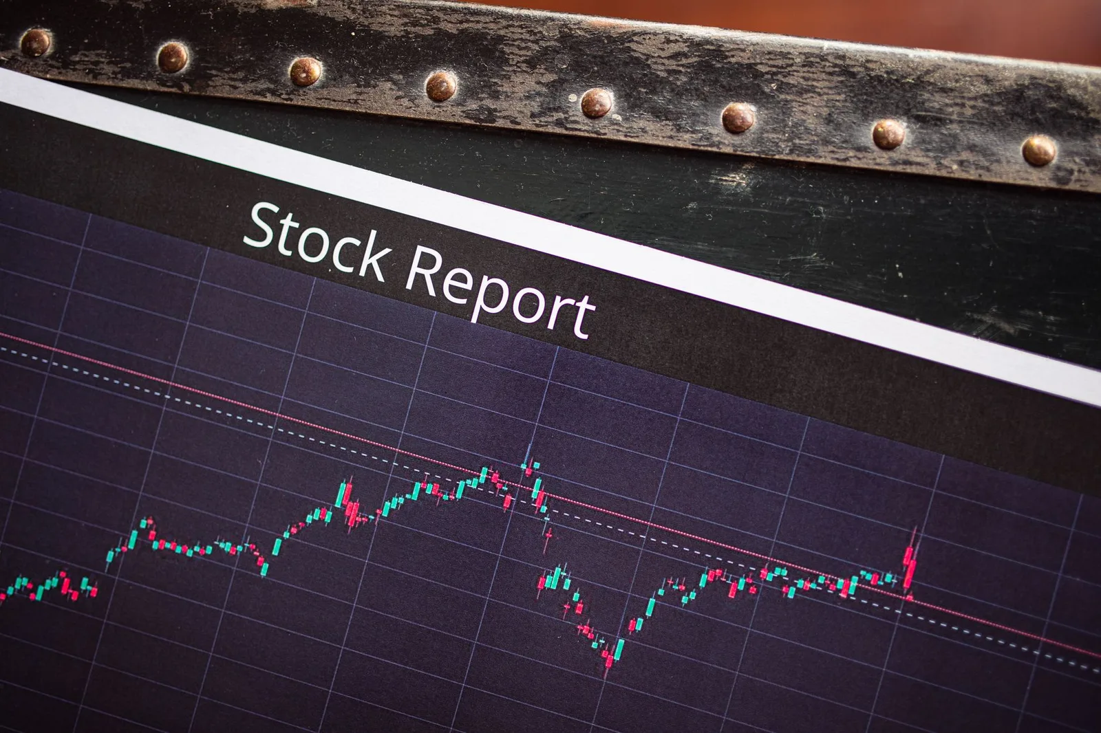Ein Bildschirm zeigt unter der Überschrift Stock Report einen Kursverlauf aus roten und grünen Kerzen
