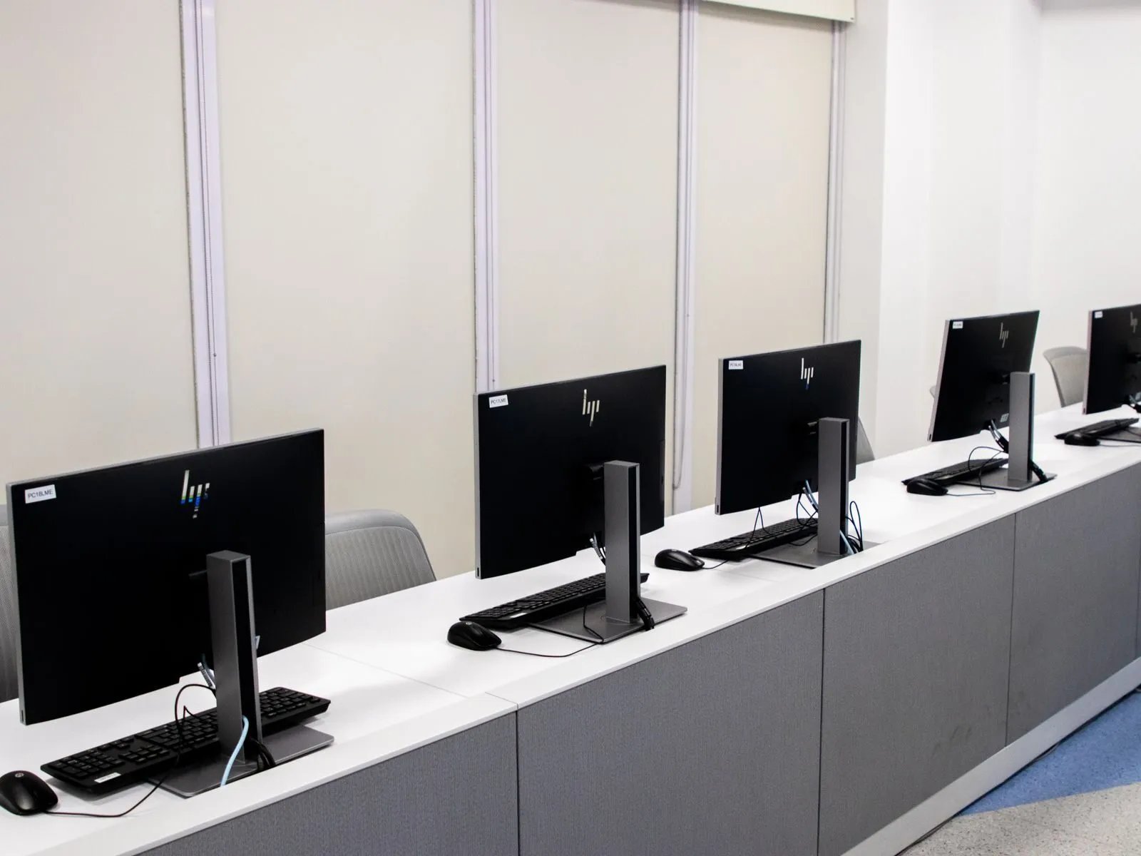Großraumbüro mit leeren Schreibtischen und Computerbildschirmen