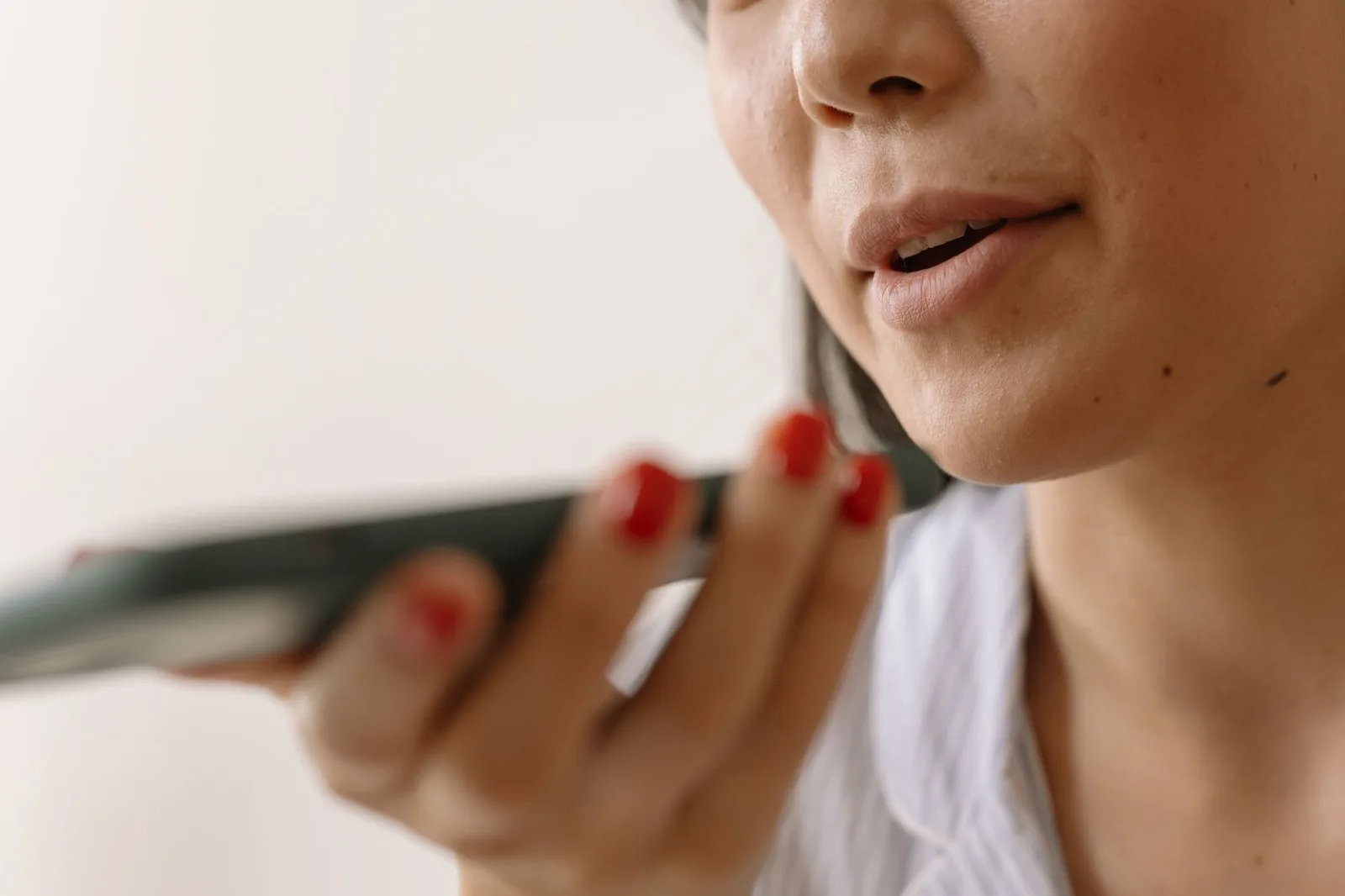 Nahaufnahme einer Person, die in ein Smartphone spricht