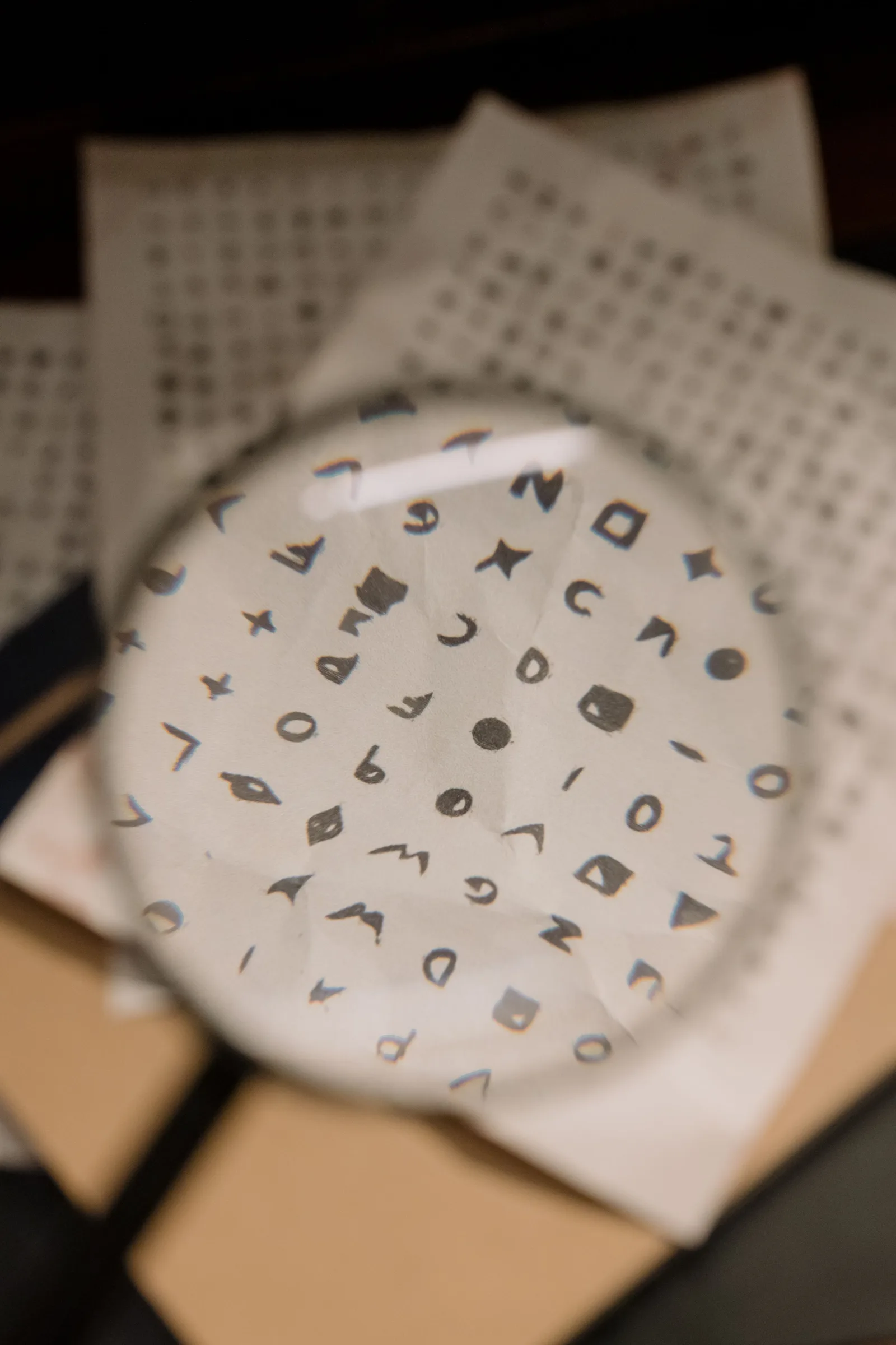 Lupe auf einem Blatt Papier, die feine Zeichen sichtbar macht