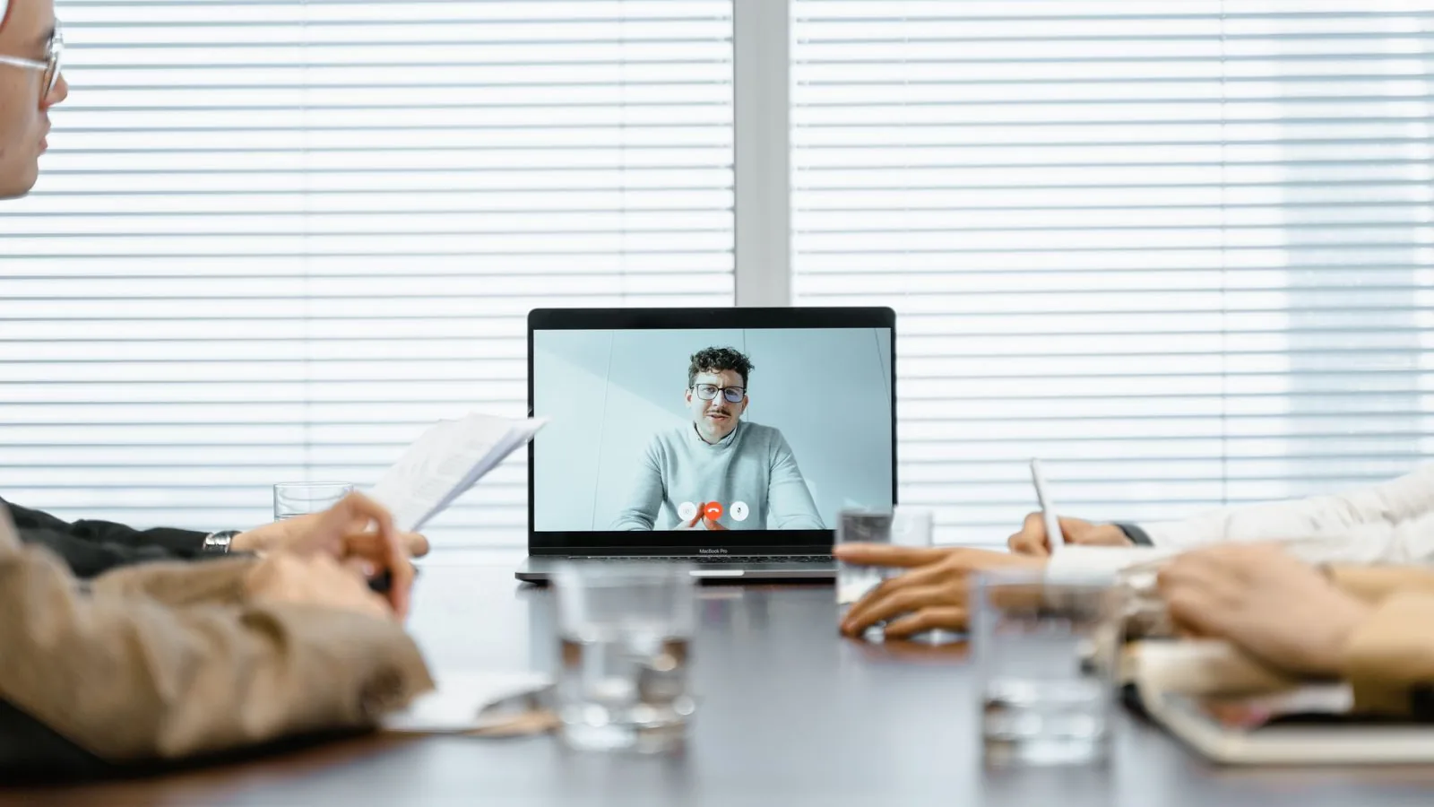 Mehrere Personen nehmen an einer Videokonferenz teil, auf dem Bildschirm sind die Teilnehmenden zu sehen