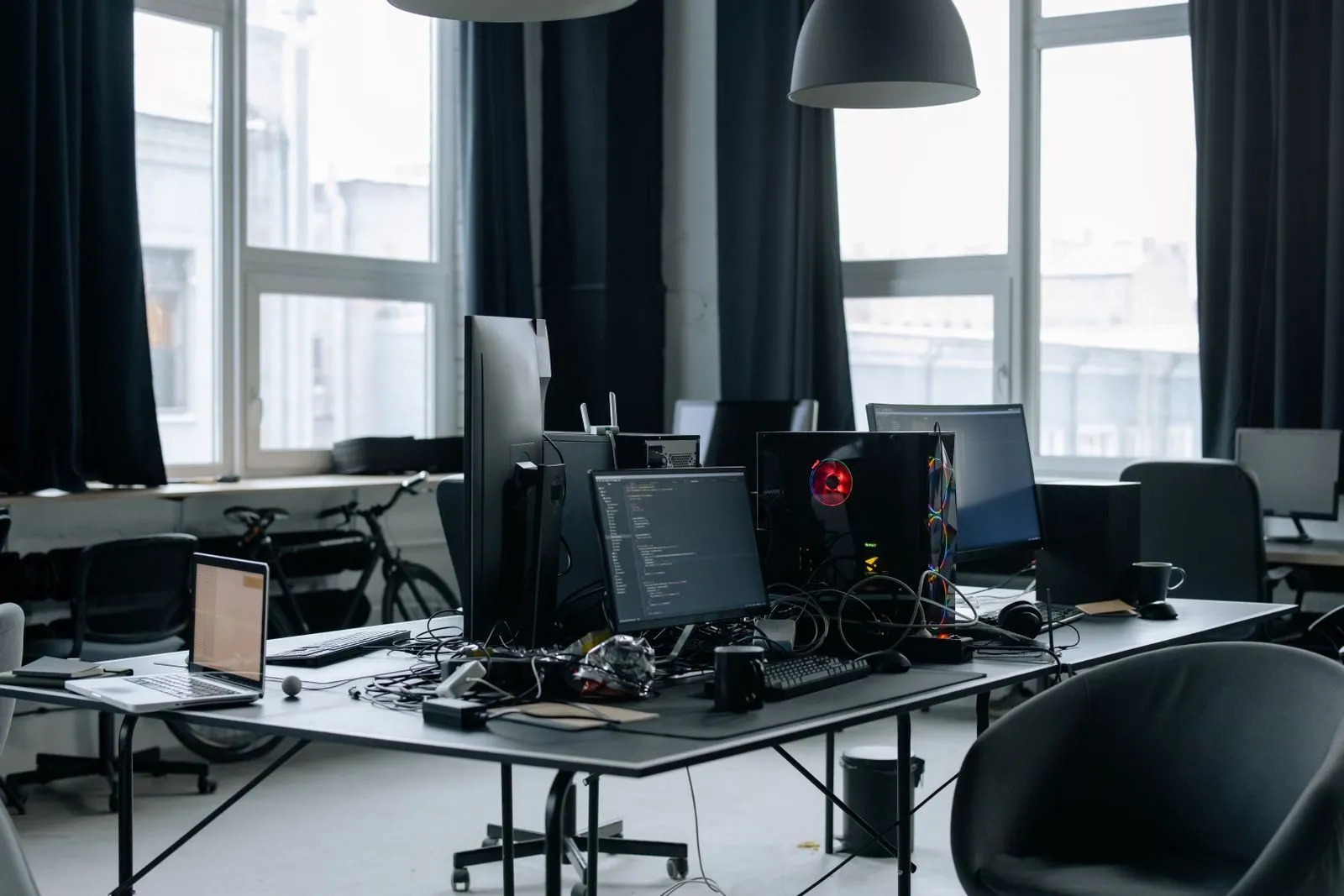 Arbeitsplatz mit mehreren Bildschirmen, auf denen Programmcode zu sehen ist
