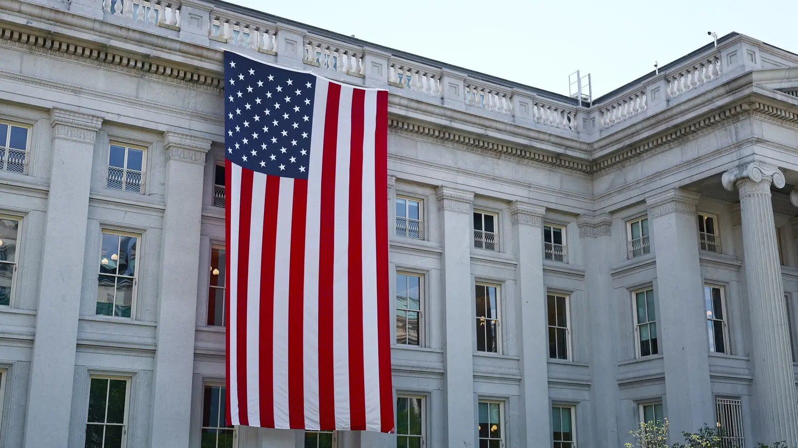 Große amerikanische Flagge an der Fassade eines historischen Regierungsgebäudes in Washington