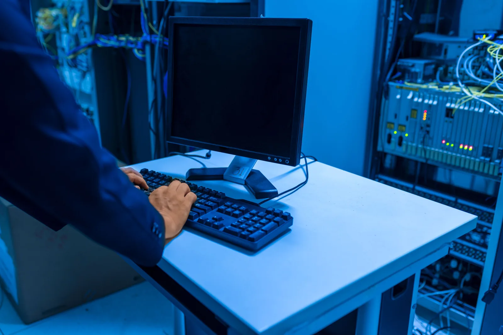 IT-Fachkraft arbeitet an einem Rechner in einem Serverraum