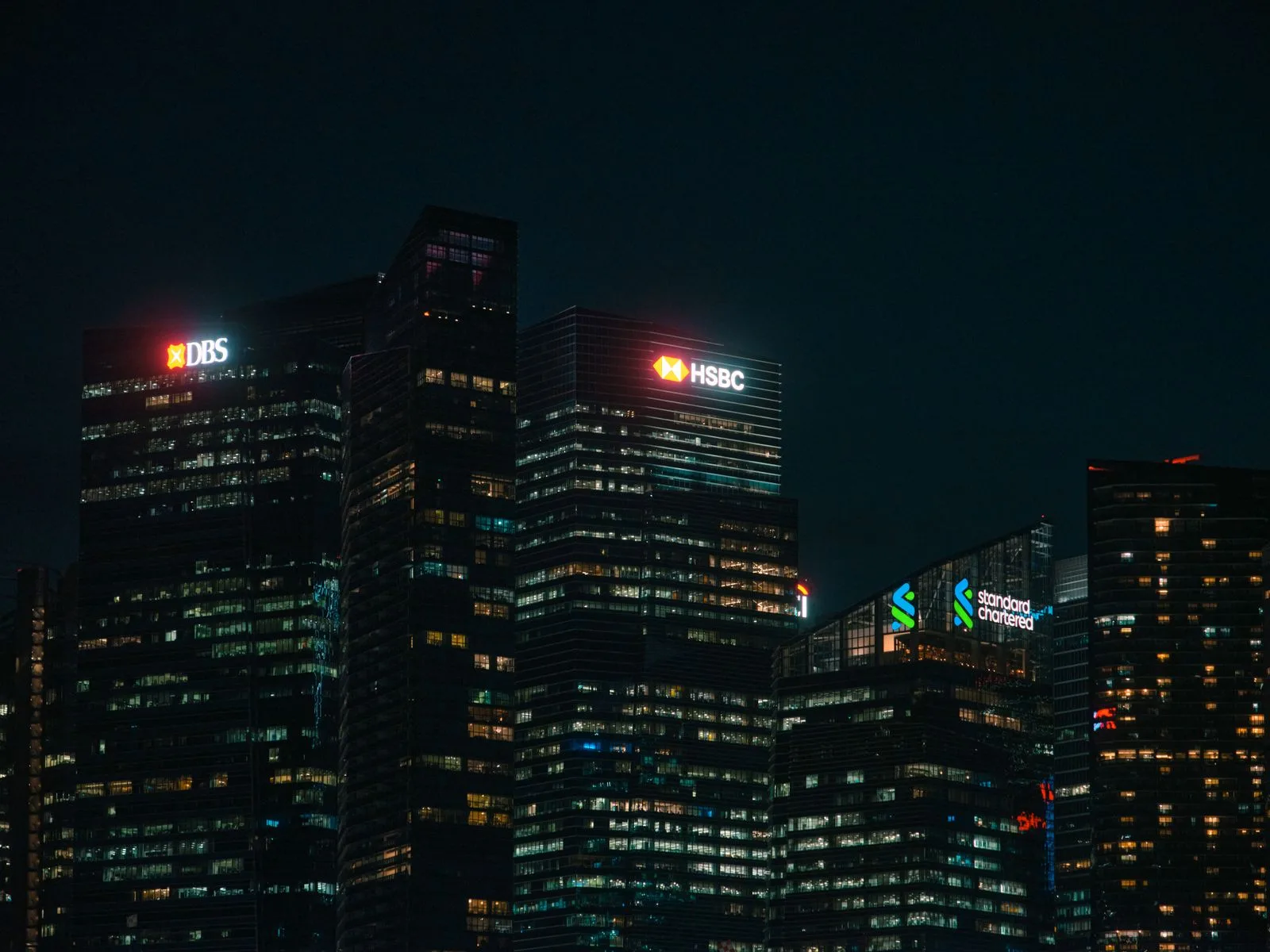 Beleuchtete Bankhochhäuser in einem Finanzviertel bei Nacht