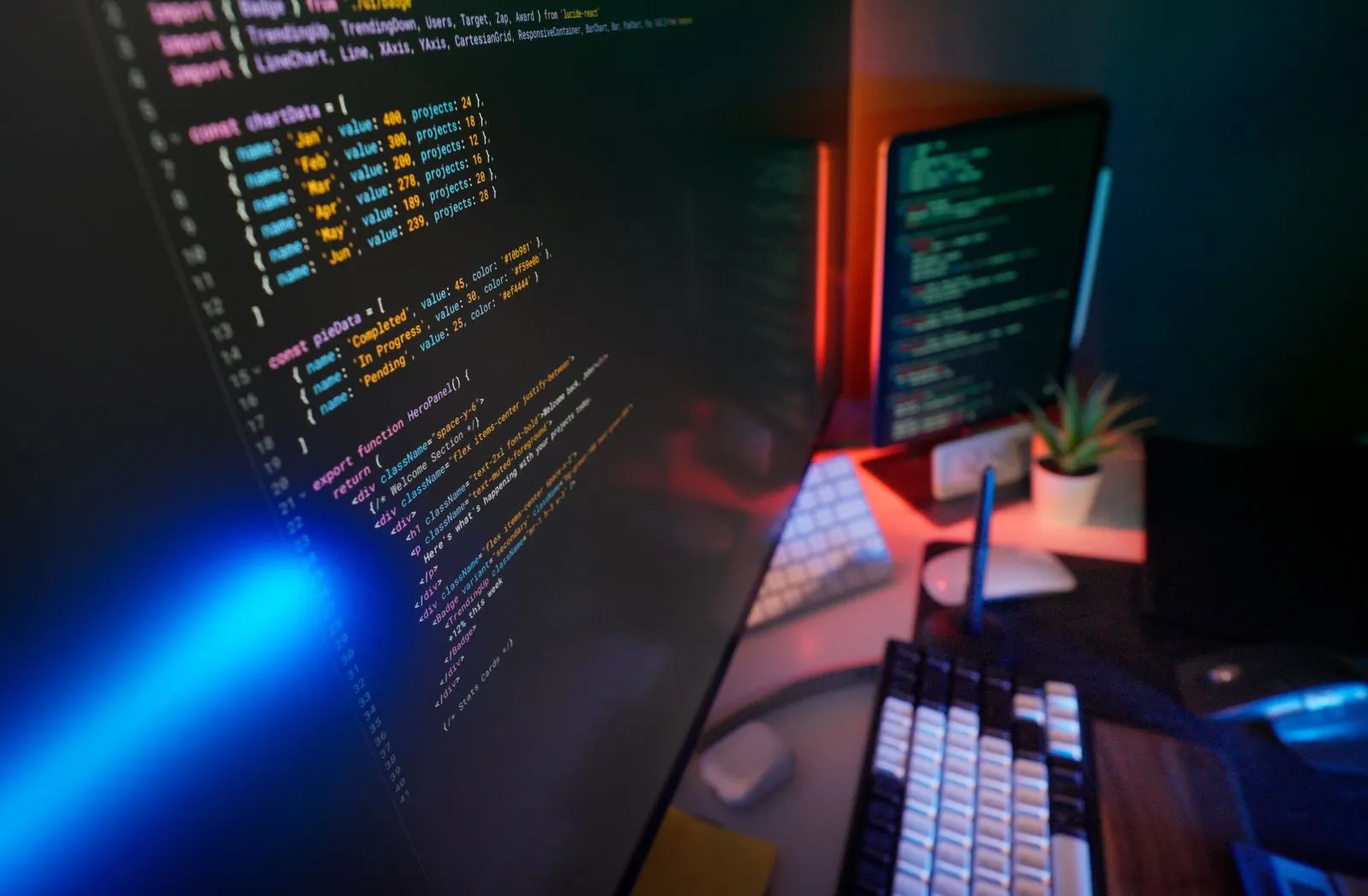 Mehrere Monitore mit farbigem Programmcode in einem Büro