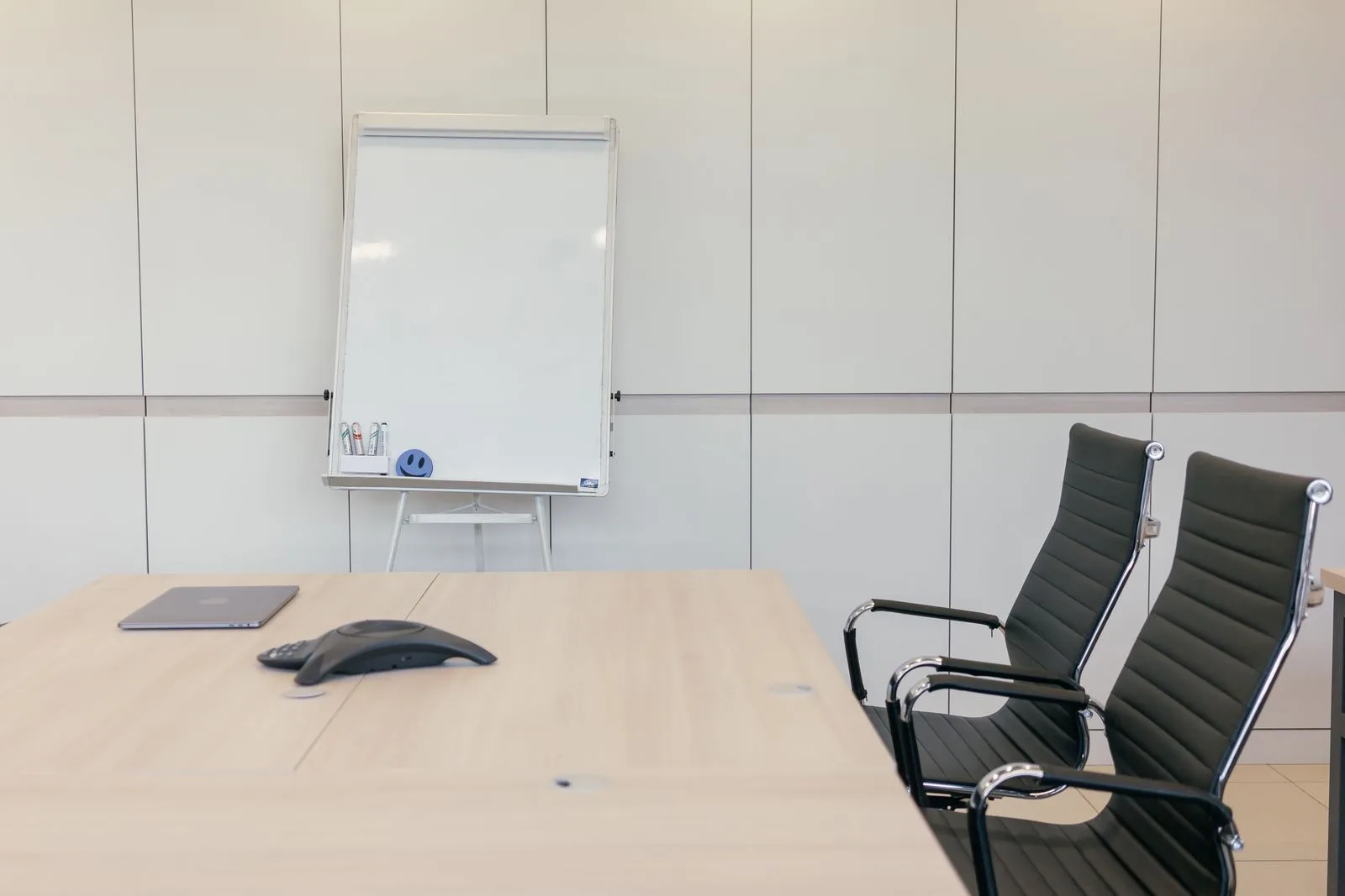 Leerer, heller Besprechungsraum mit Tisch, Stühlen und Whiteboard