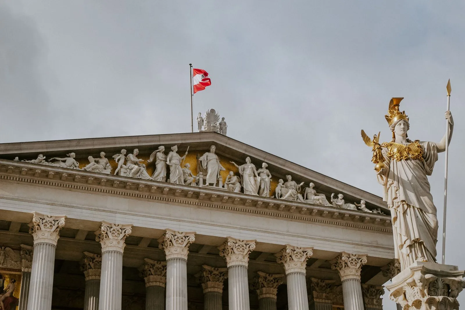 Das österreichische Parlamentsgebäude in Wien mit Athene-Statue und Nationalflagge