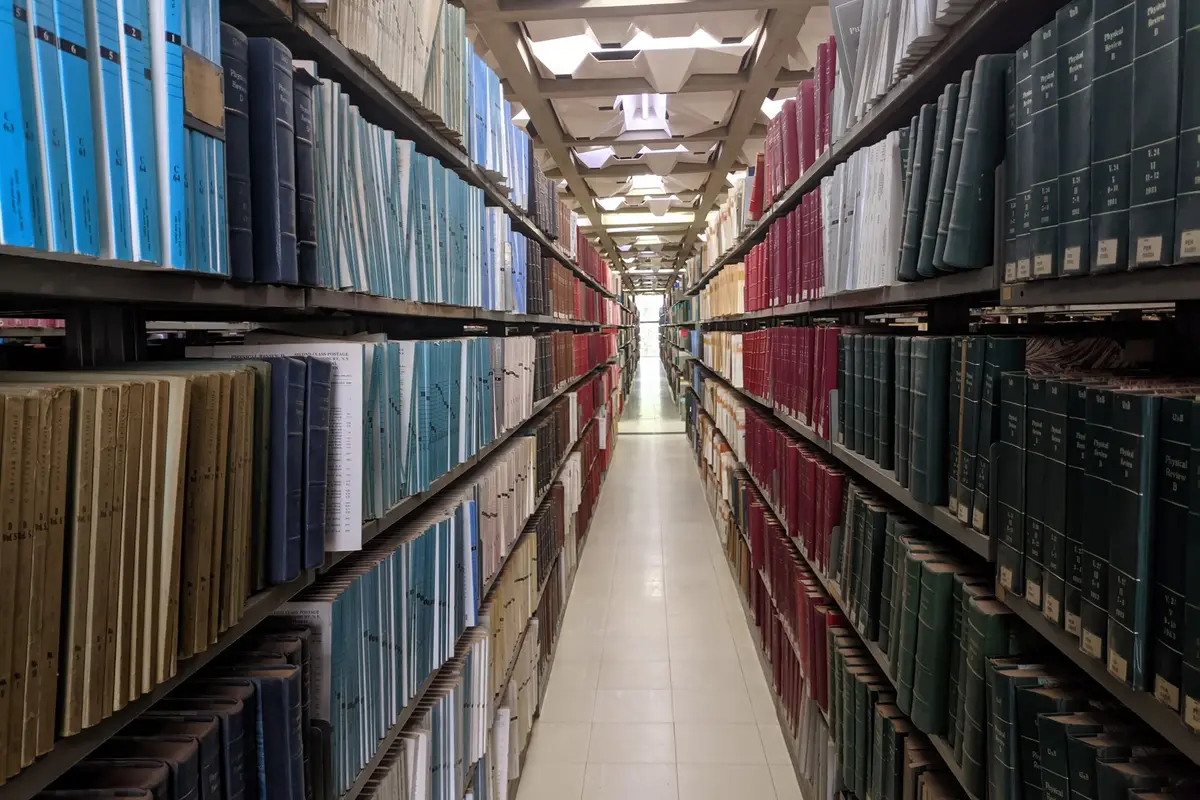 Langer Gang in einer Bibliothek mit dicht gefüllten Bücherregalen