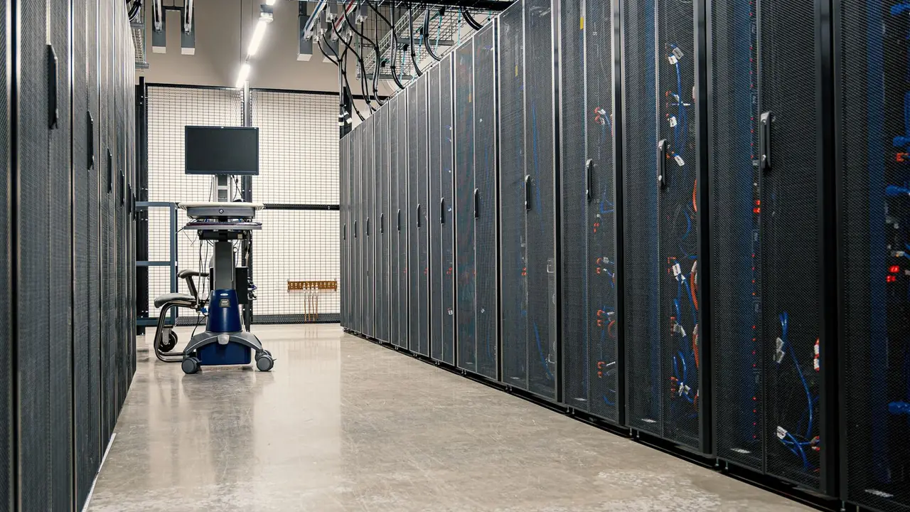 Serverschränke in einem Rechenzentrum, dahinter Netzwerkkabel und Verteiler