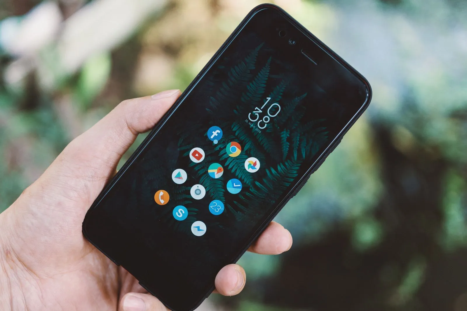 Hand hält ein Smartphone mit App-Symbolen auf dem Bildschirm