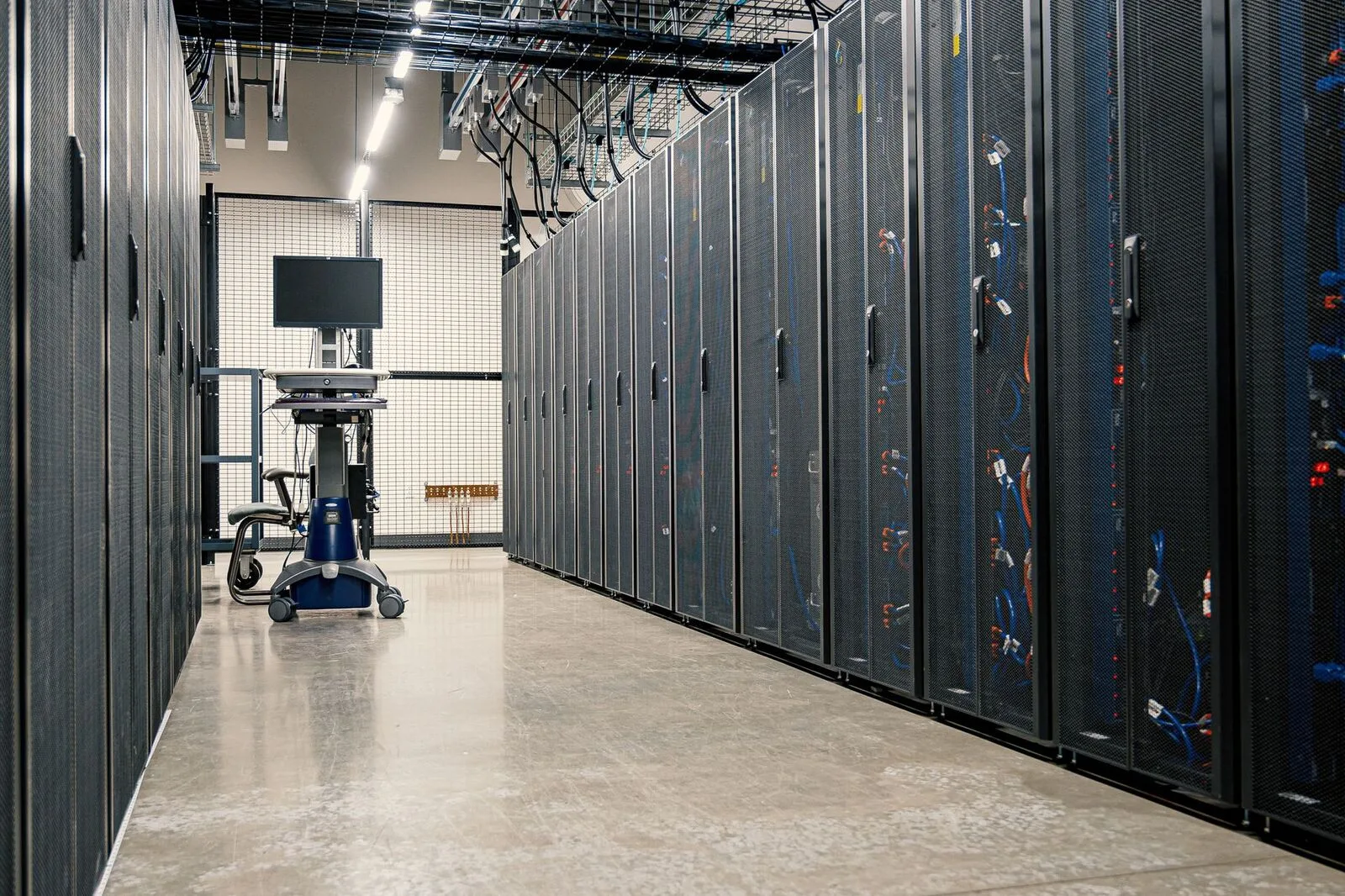 Reihen von Serverschränken mit Netzwerktechnik und Kabeln in einem Rechenzentrum
