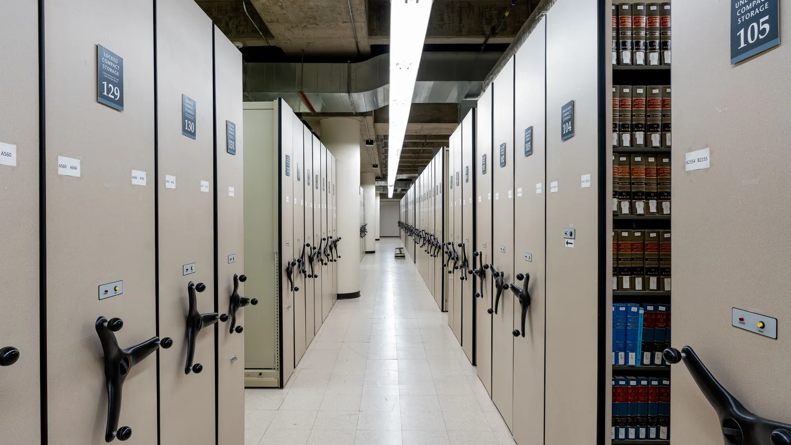 Archivraum mit dicht stehenden Rollregalen voller Aktenordner
