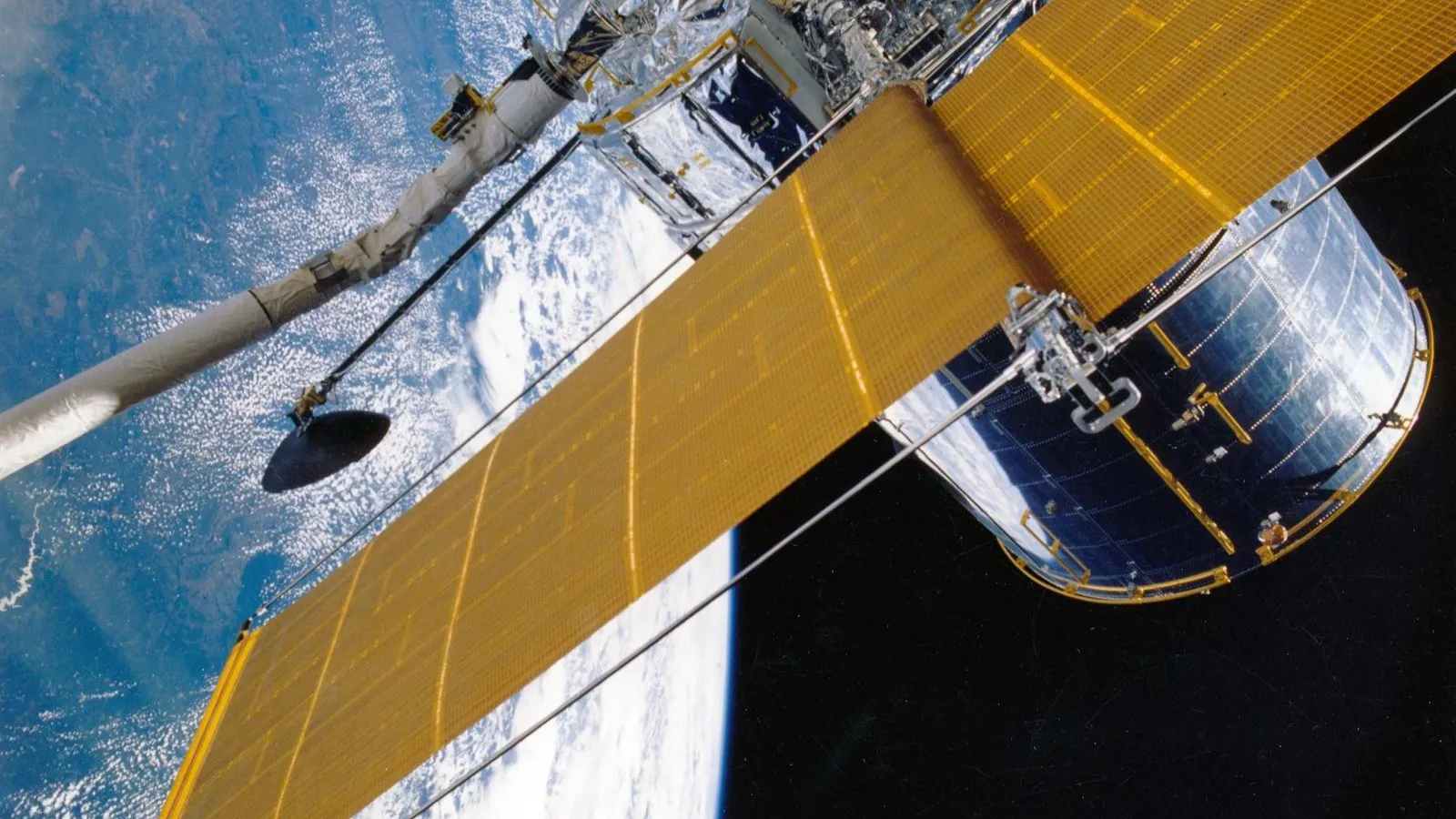Satellit mit ausgefahrenen Solarpaneelen über der Erde