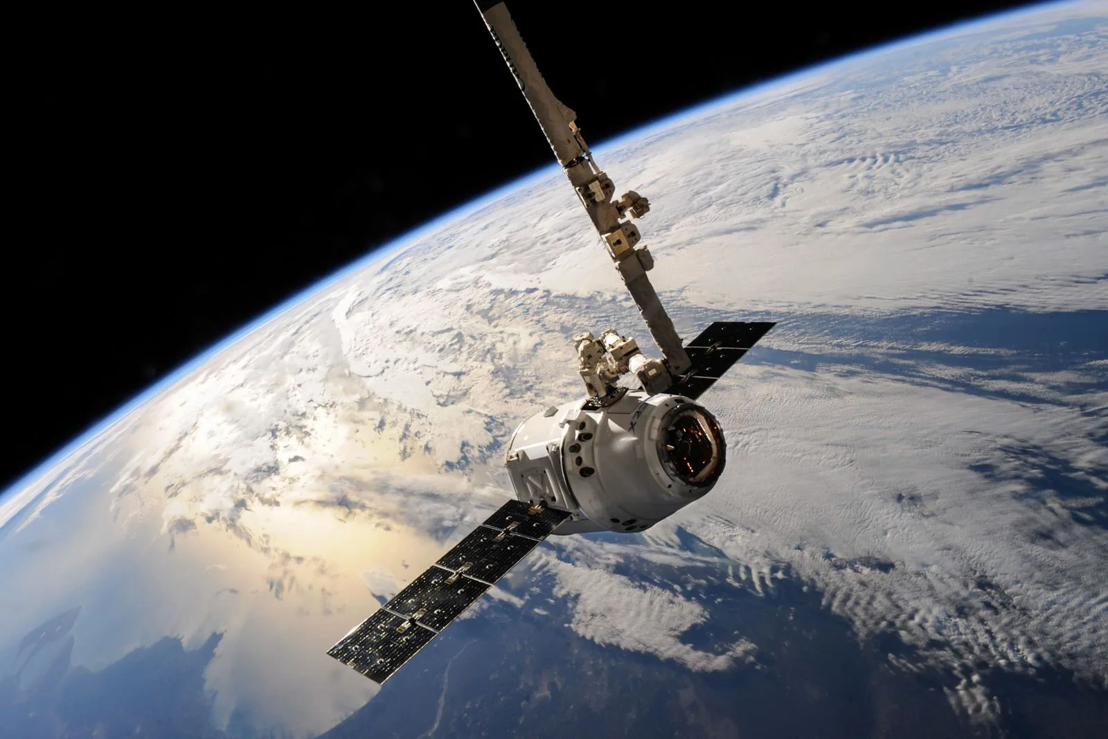 Satellit im Erdorbit über einer Wolkendecke, aufgenommen aus dem Weltraum